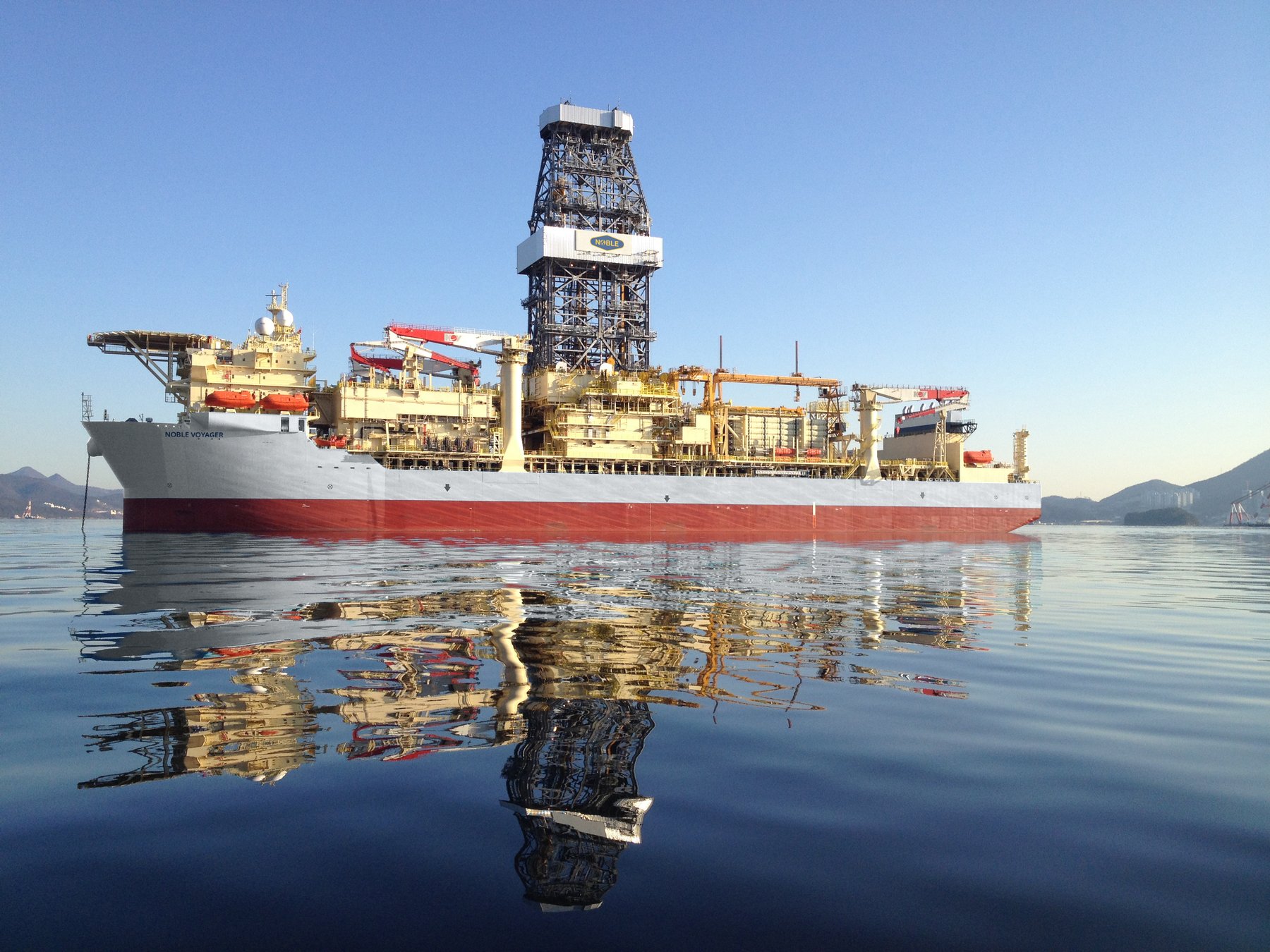 Noble Voyager at anchor, mirror-calm water